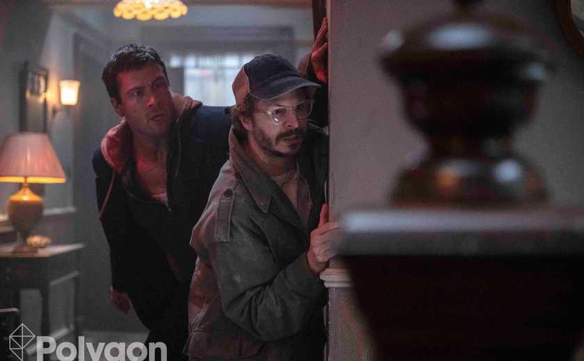 Michael Cera and Glen Powell peaking around a corner in The Running Man 2025